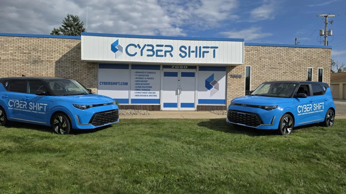 Two blue Cyber Shift branded vehicles parked on the lawn in front of the Cyber Shift office in North Canton, Ohio. Two blue Cyber Shift branded vehicles parked on the lawn in front of the Cyber Shift office in North Canton, Ohio.