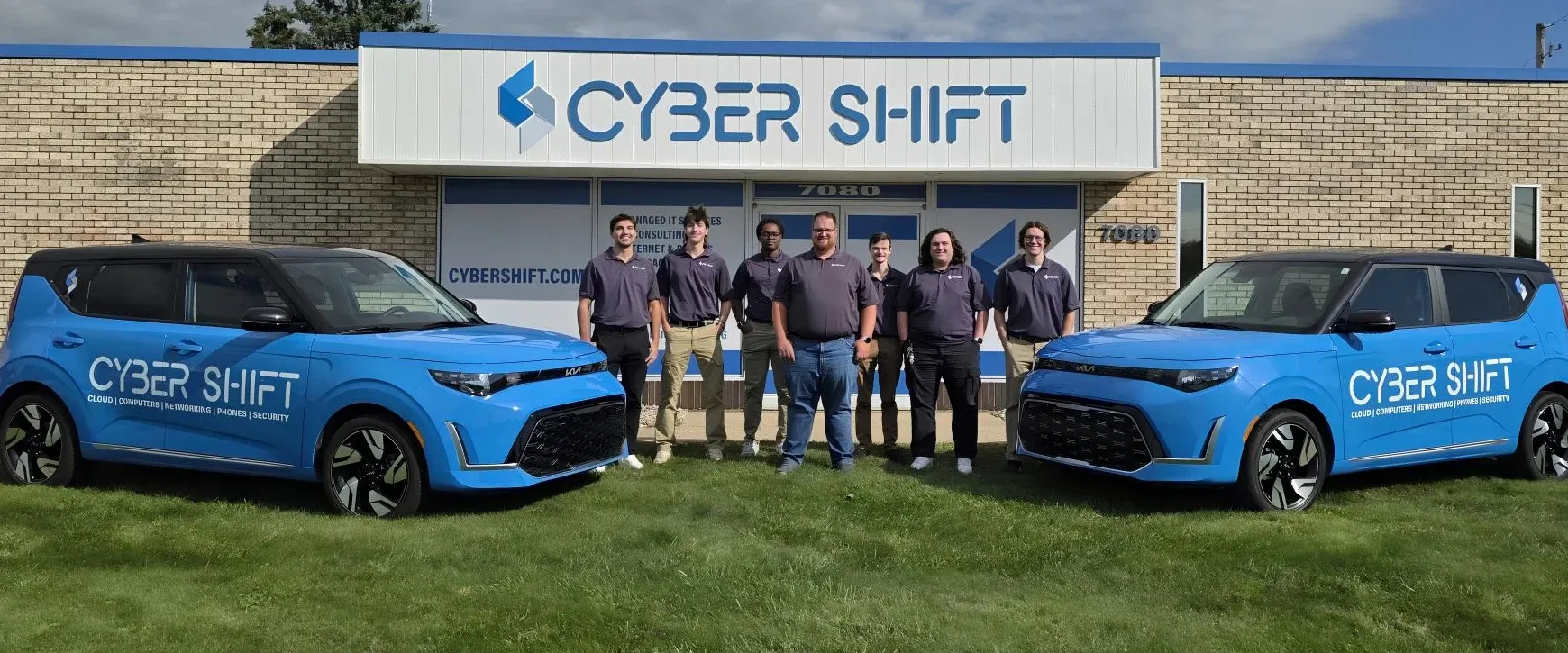 Seven members of the Cyber Shift team standing between two branded vehicles outside the North Canton office. Seven members of the Cyber Shift team standing between two branded vehicles outside the North Canton office.