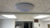 A ceiling-mounted wireless access point and an interior view at Sancta Clara Monastery