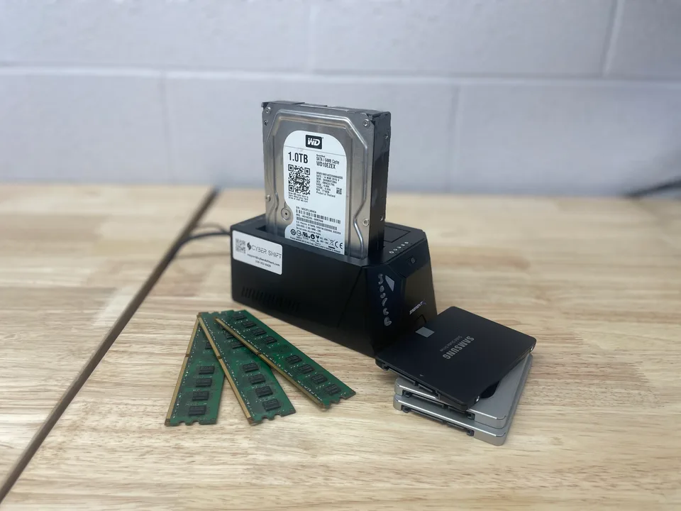 A drive dock, storage drives and memory modules on a workbench A drive dock, storage drives and memory modules on a workbench