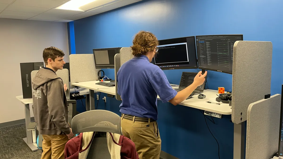 Two team members working together at an office workstation