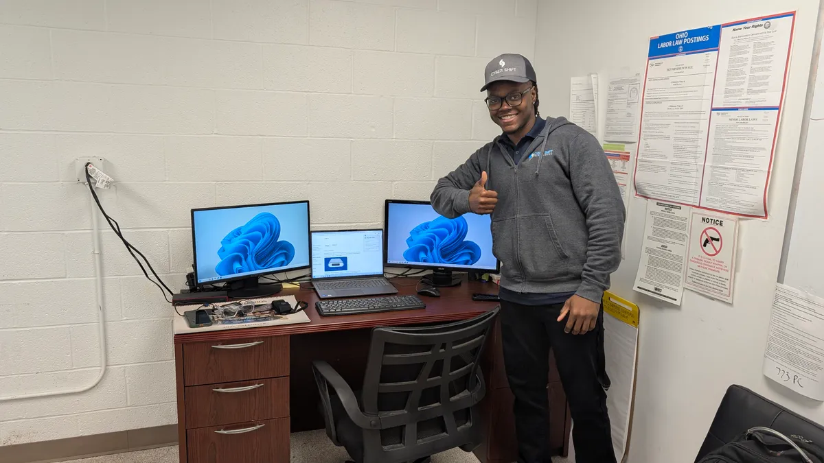 A technician at a business workstation with two monitors A technician at a business workstation with two monitors